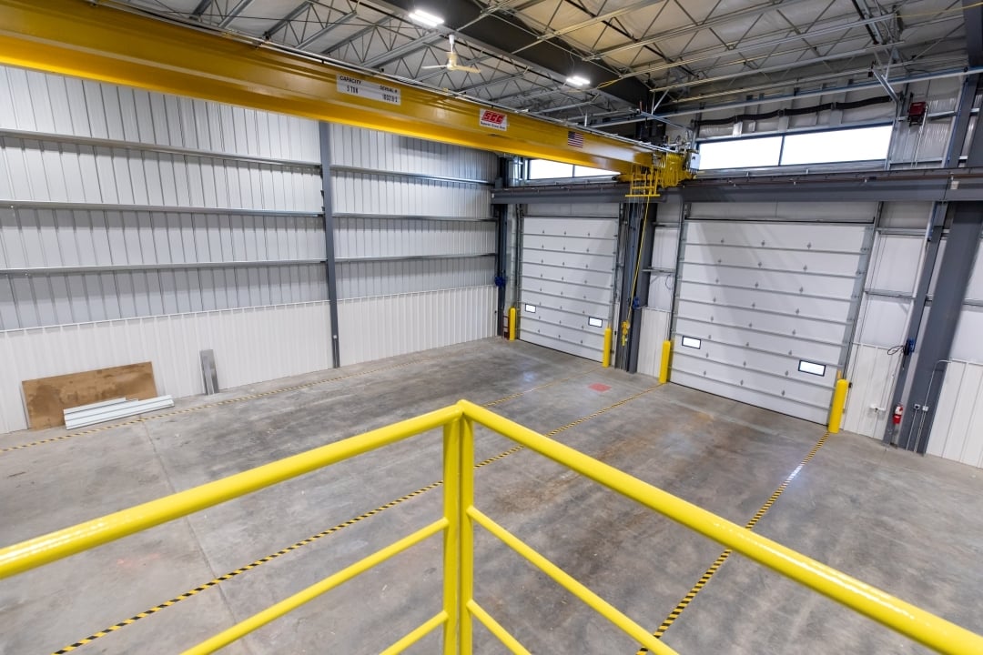 High-bay shop interior at Landwehr Construction facility with overhead doors and crane system, constructed by Rice Companies.