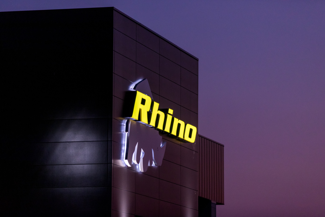 Exterior of manufacturing facility showing illuminated building facade, constructed by Rice Companies