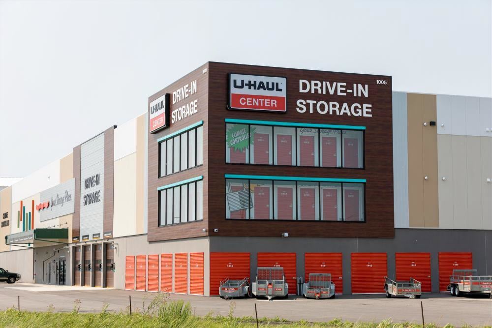 Wide exterior view of U‑Haul drive‑in storage complex with visible loading zones and orange roll‑up doors, built by Rice Companies.