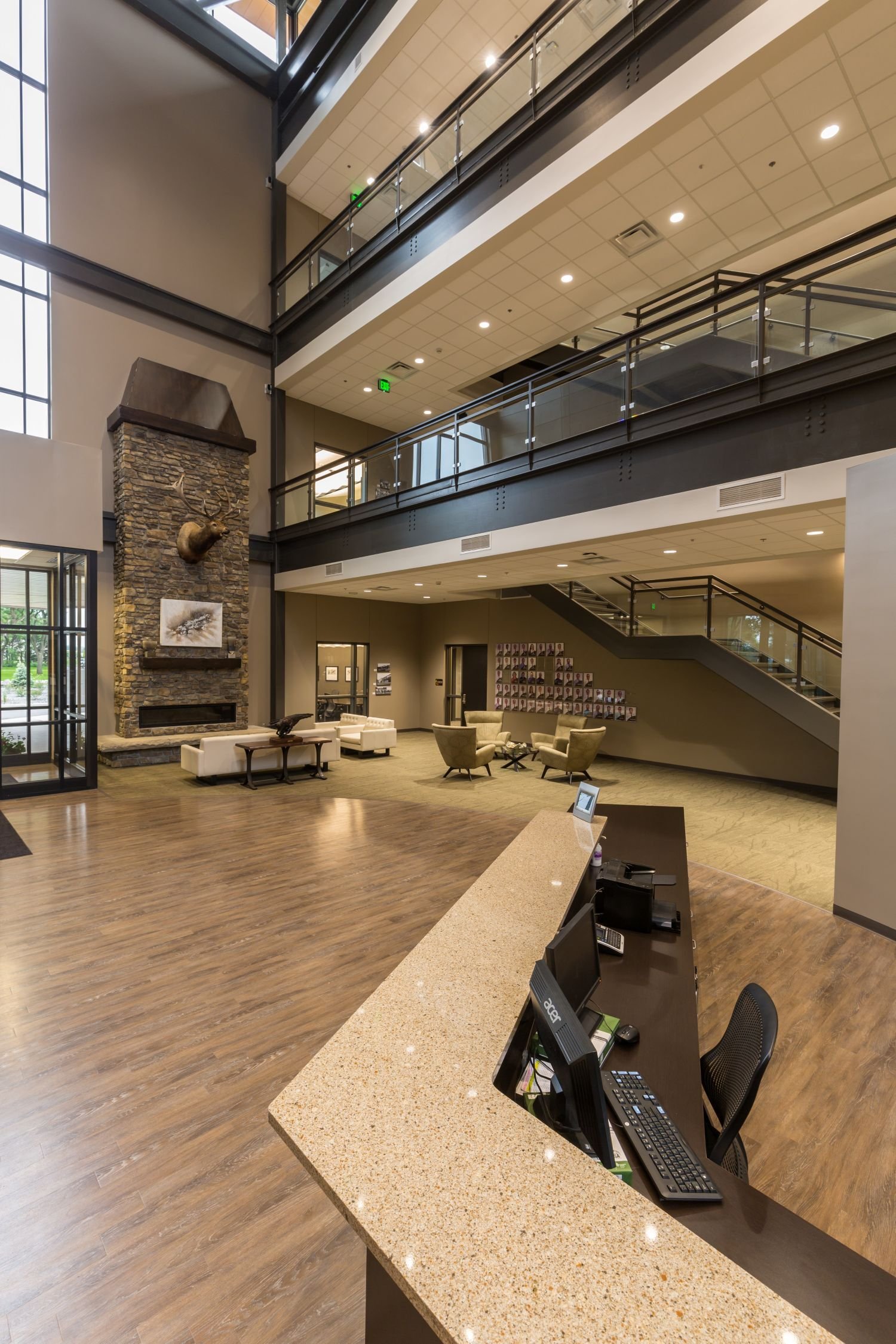 Corporate office lobby with stone fireplace and open staircase constructed by Rice Companies