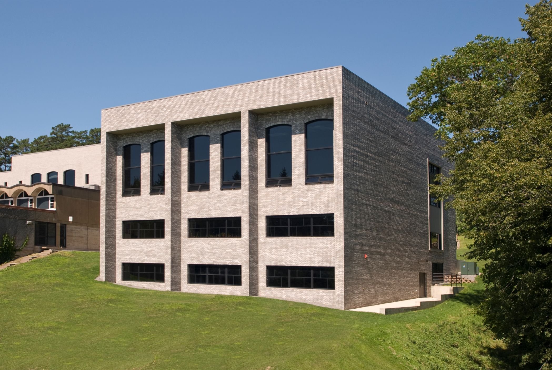 Exterior of academic building showing large windows and campus connection, constructed by Rice Companies