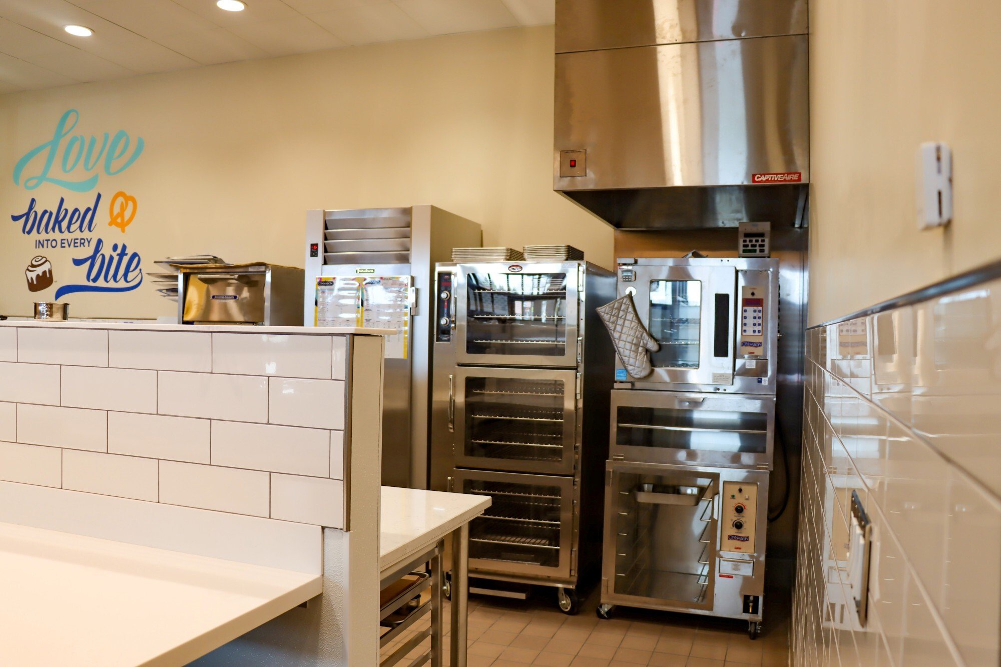 Interior of retail food service space showing commercial kitchen equipment and preparation area, constructed by Rice Companies