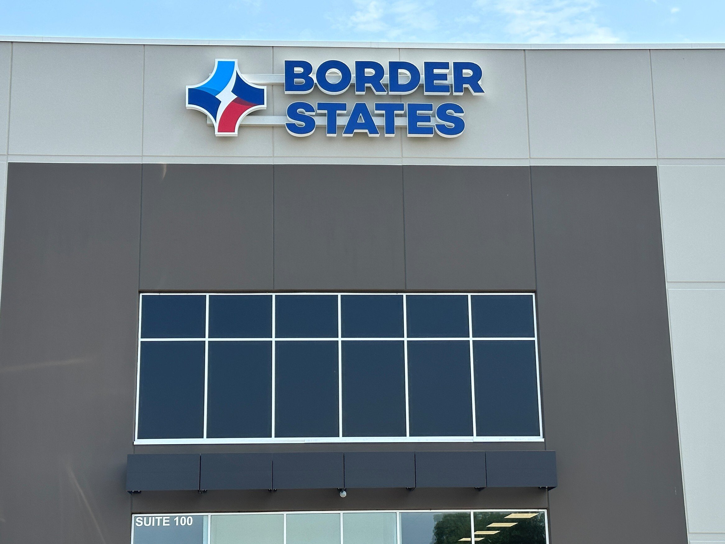 Exterior of warehouse and office facility showing branded facade and storefront windows, constructed by Rice Companies.