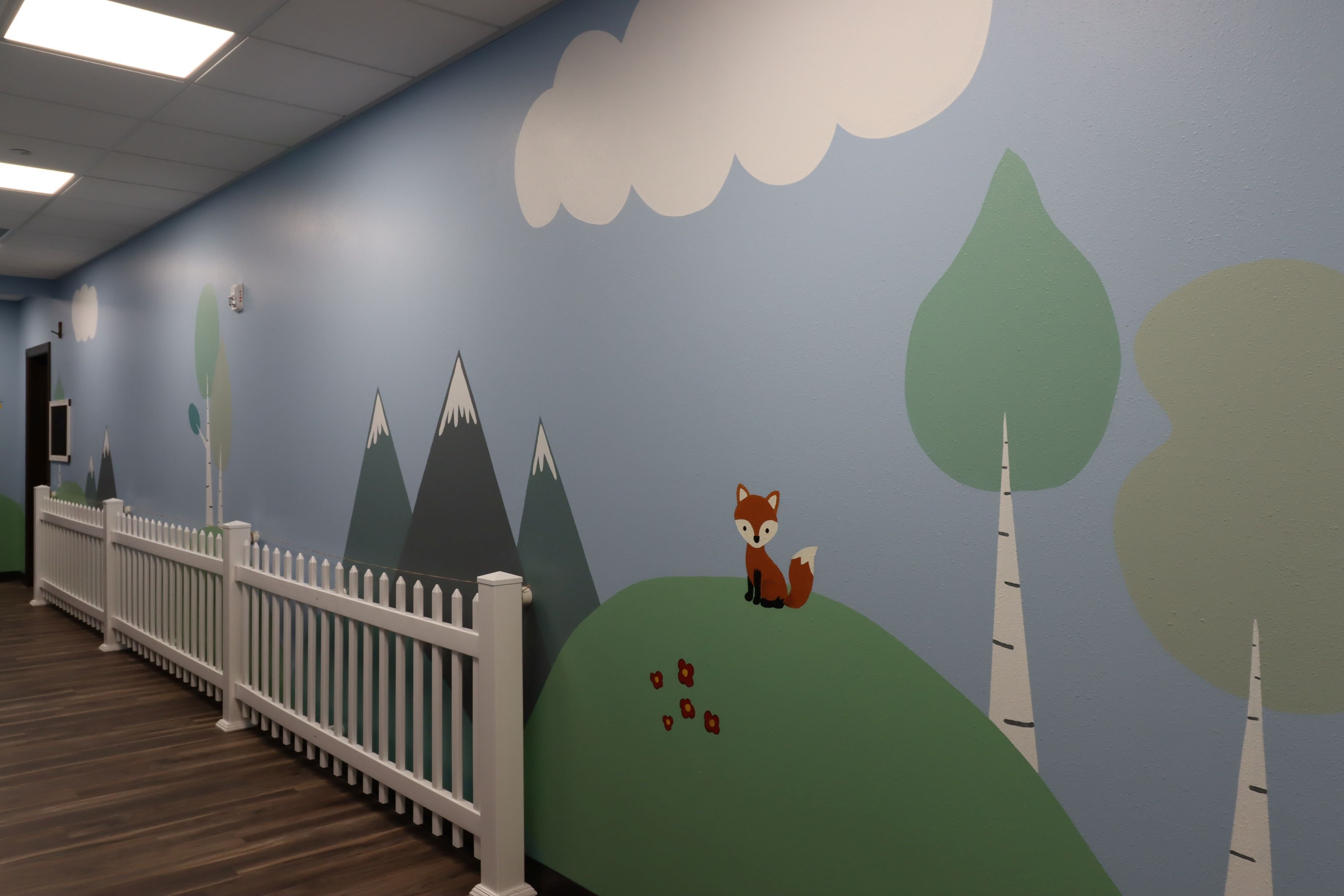 Interior hallway at Jr’s Academy with a playful wall mural, child-height detailing, and learning-friendly finishes, constructed by Rice Companies.