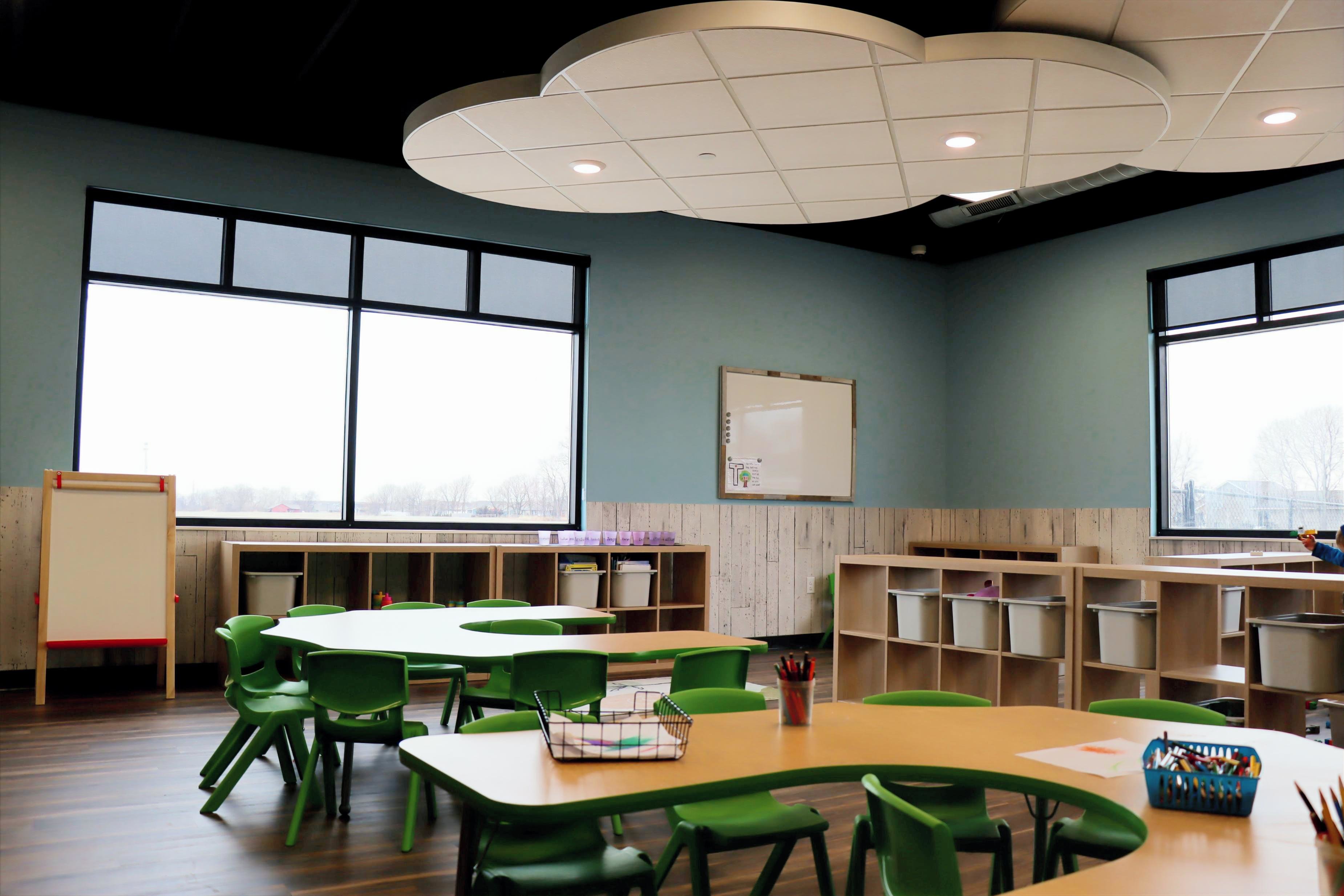 Interior classroom at Jr’s Academy featuring child-sized tables, open shelving, and bright learning space, constructed by Rice Companies.