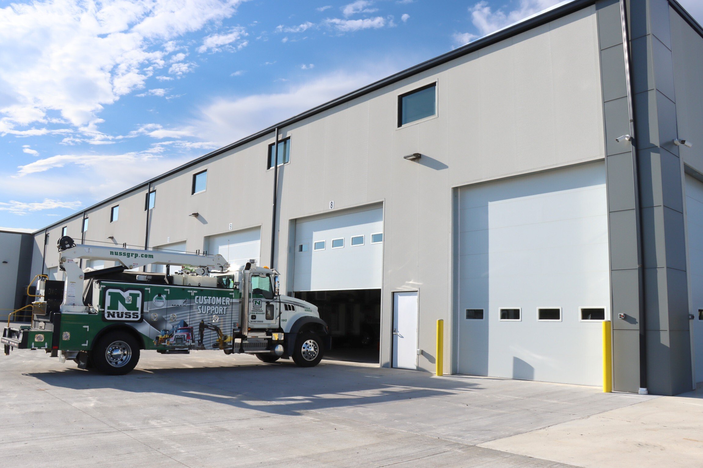 Exterior of commercial service facility showing overhead service doors and equipment access, constructed by Rice Companies