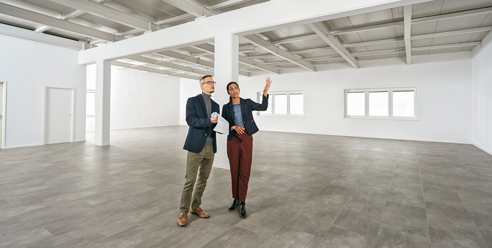 man-and-woman-discussing-empty-commercial-space-with-high-ceilings man-and-woman-discussing-empty-commercial-space-with-high-ceilings