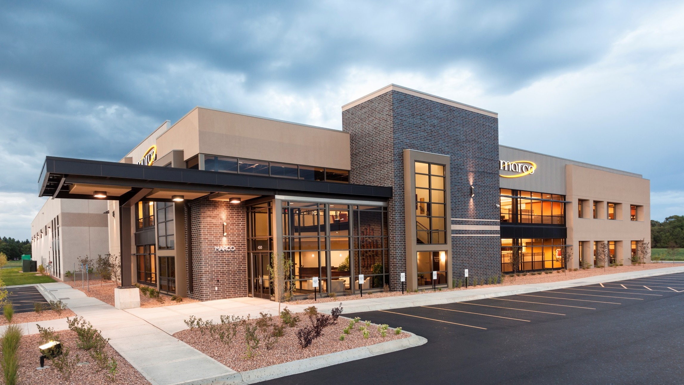 Exterior of corporate headquarters with glass entry and modern brick and metal finishes, constructed by Rice Companies