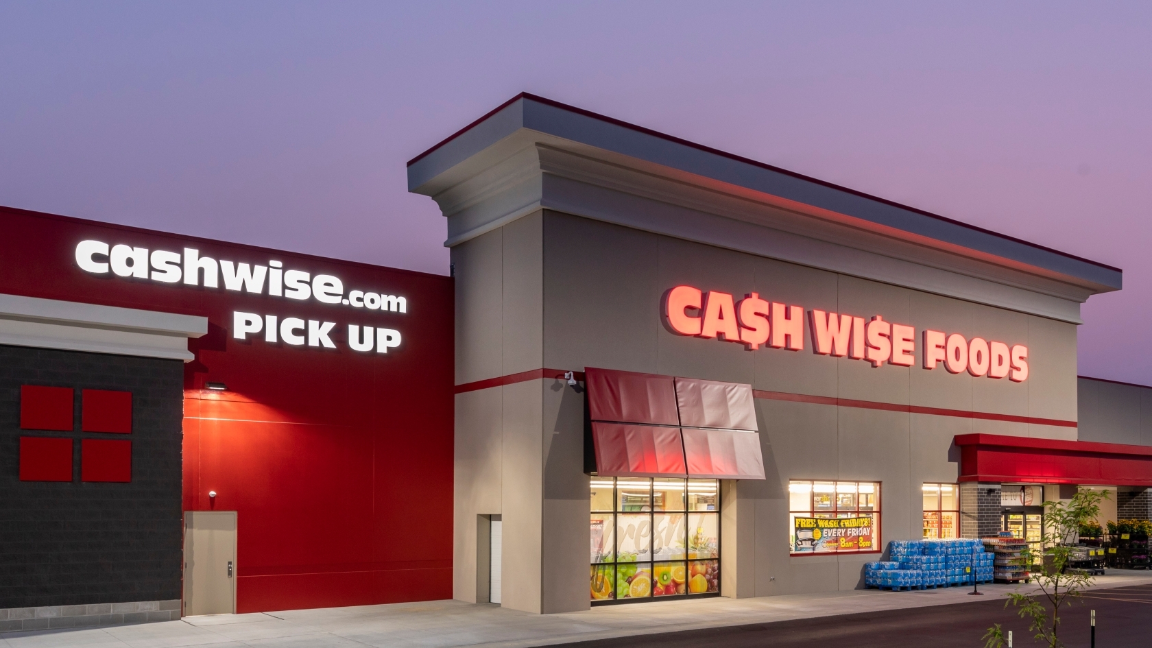 Exterior of grocery store showing illuminated storefront facade and main entrance, constructed by Rice Companies