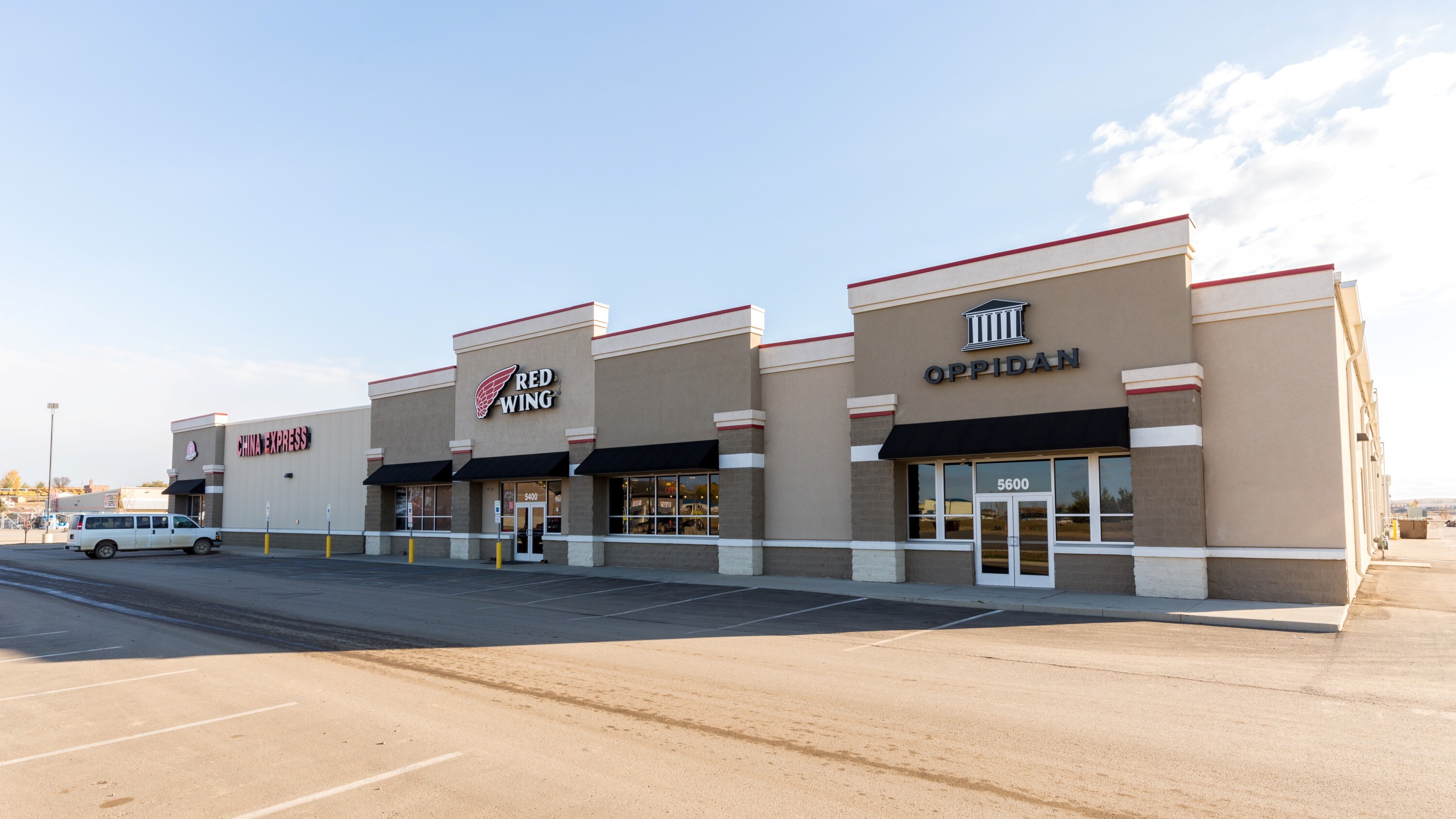 Exterior of commercial retail center showing multi-tenant storefronts and site parking, constructed by Rice Companies
