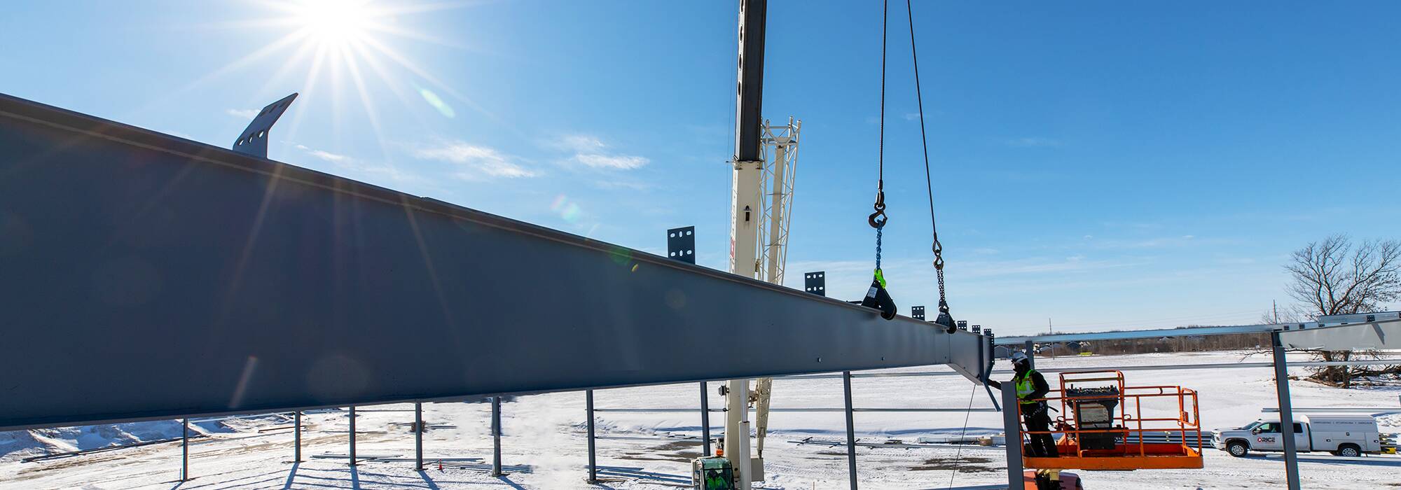 Beam attached to crane being placed on foundation