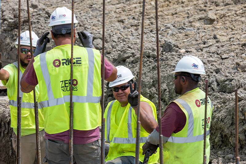 Workers working behind rebar pipes