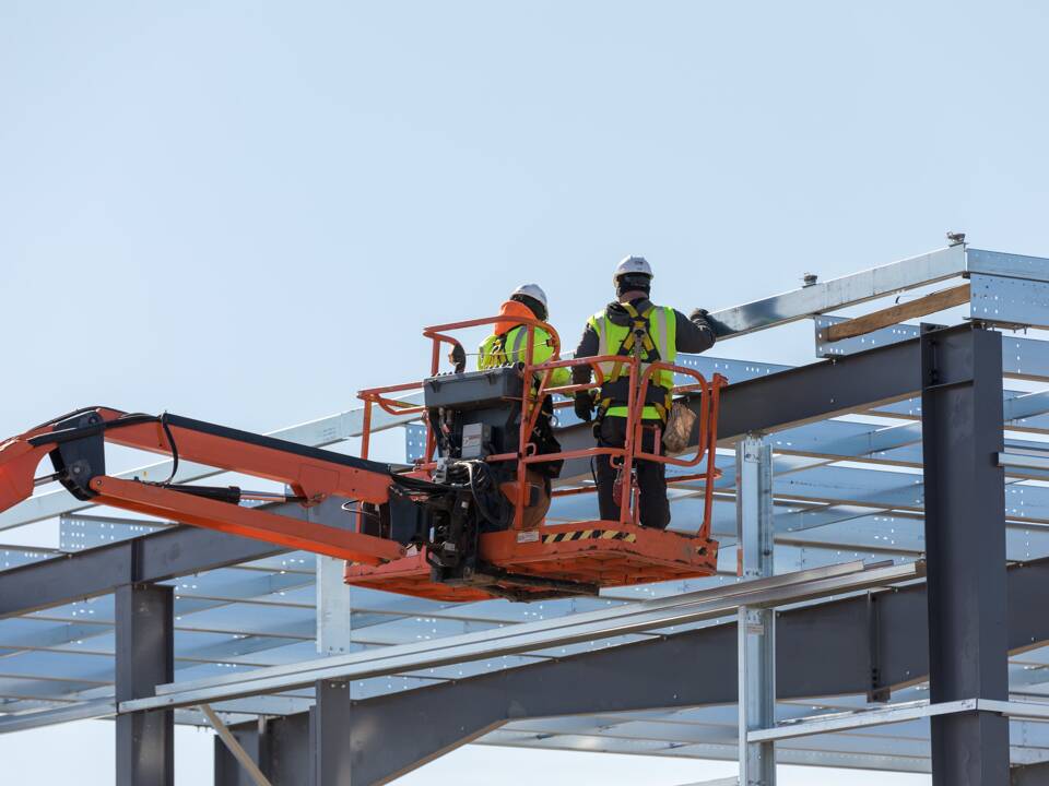 Workers constructing steel building