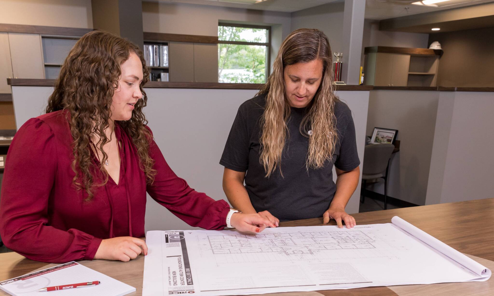 Office workers reviewing blue prints