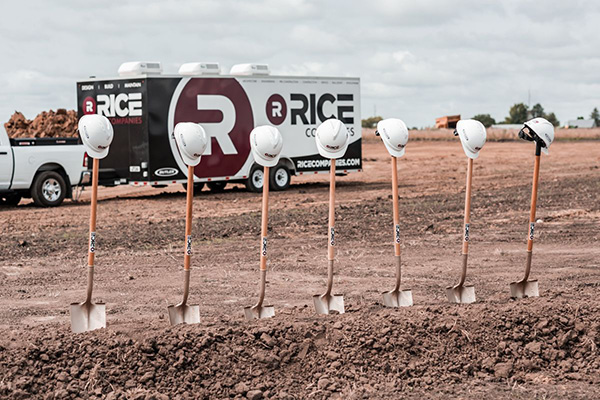 Line of shovels with hard hats at ground breaking